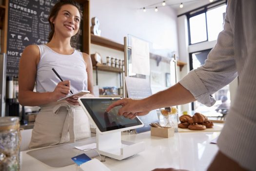 Customer using touch screen to make payment at a coffee